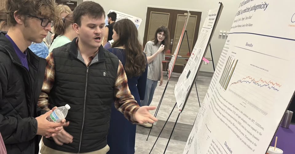 Students presenting genetic research poster