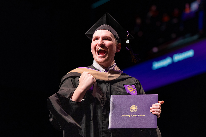 Image of a UNA graduate with a diploma