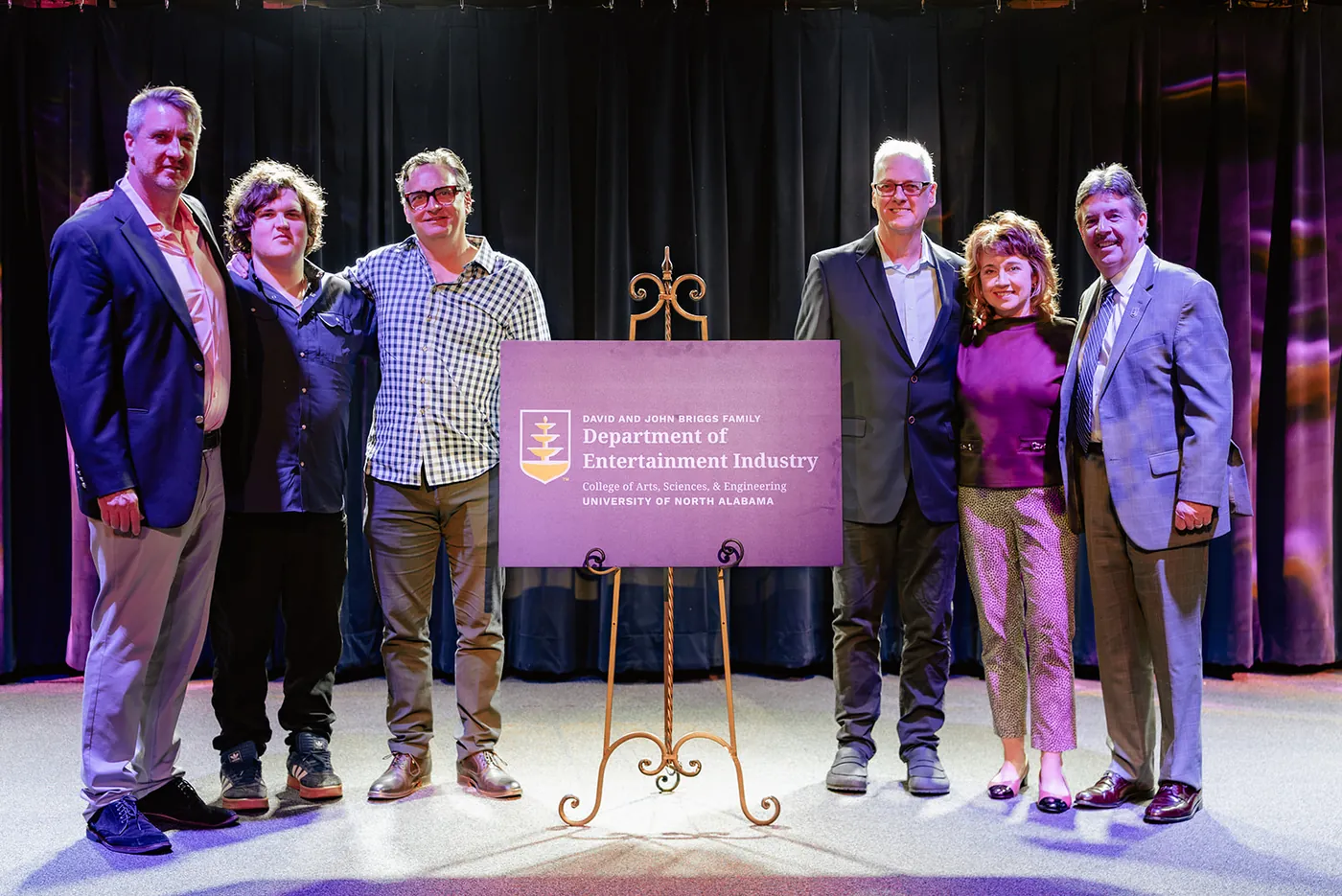 President Kitts and others taking a photo at a Department of Entertainment Industry sign
