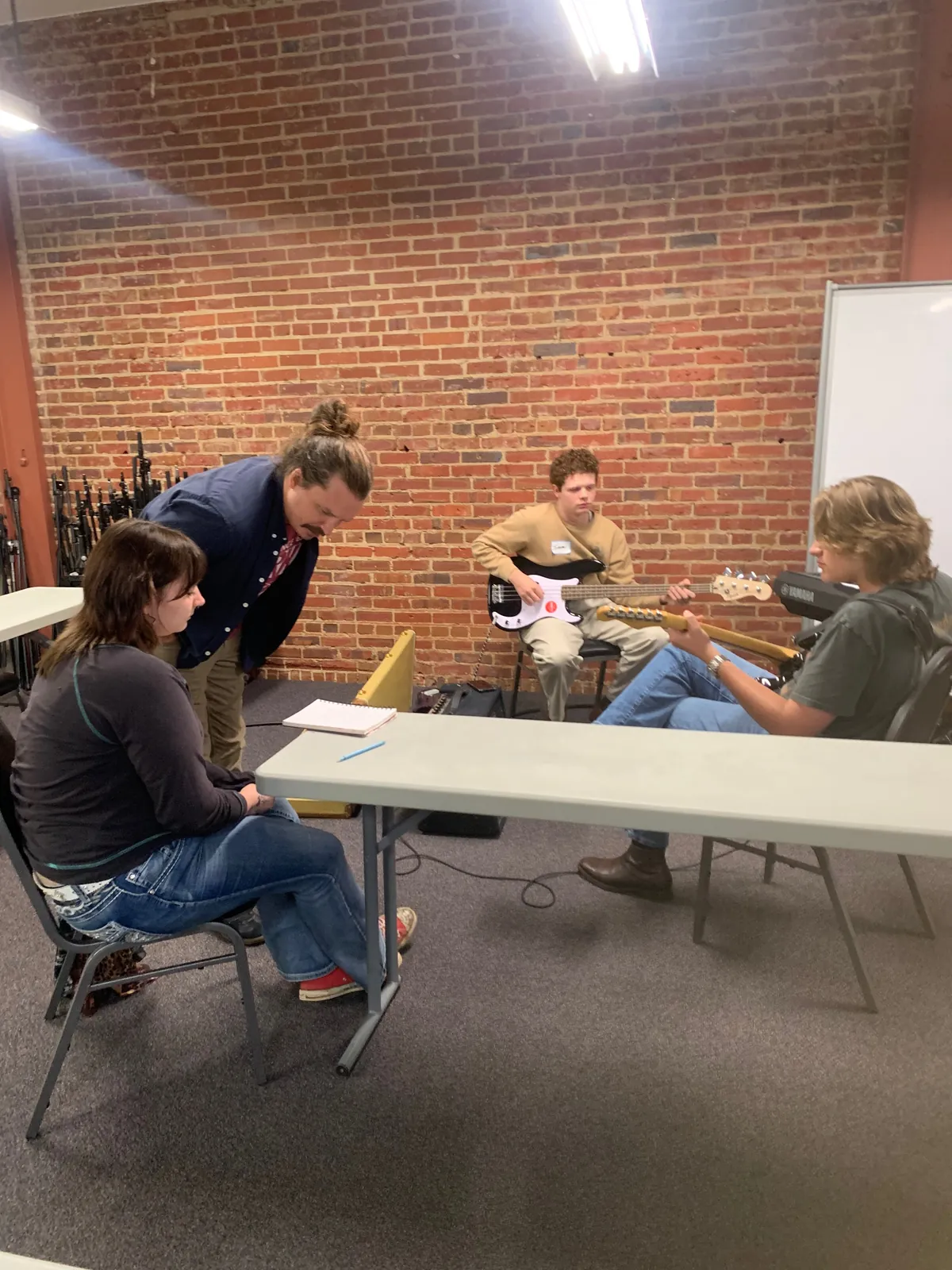 Camp members playing guitar, speaking to each other