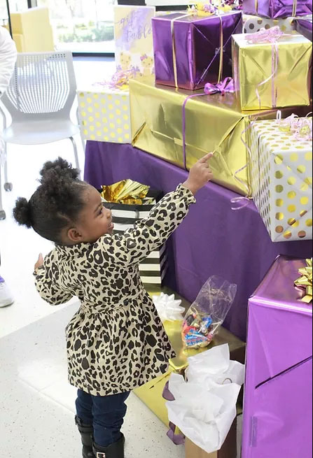 image of child with purple and gold wrapped presents