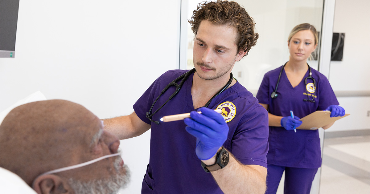 Students are able to use the simulation lab in Harrison Hall. Here, a man and woman in the nursing program run tests on a simulation person.