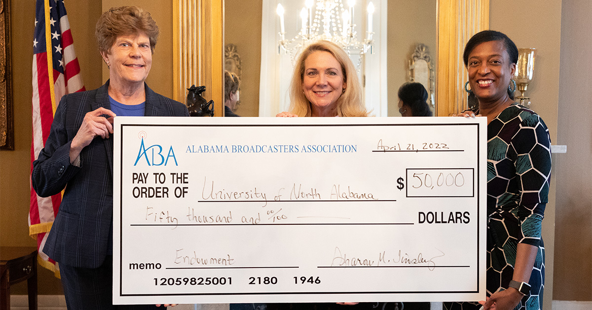 College of Arts, Sciences, and Engineering Dean Dr. Sara Lynn Baird, left; and Dr. Pat Sanders, professor and Chair of the Department of Communication, right, accept the $50,000 Endowed Scholarship Award from Sharon Tinsley, Alabama Broadcasters Association President.
