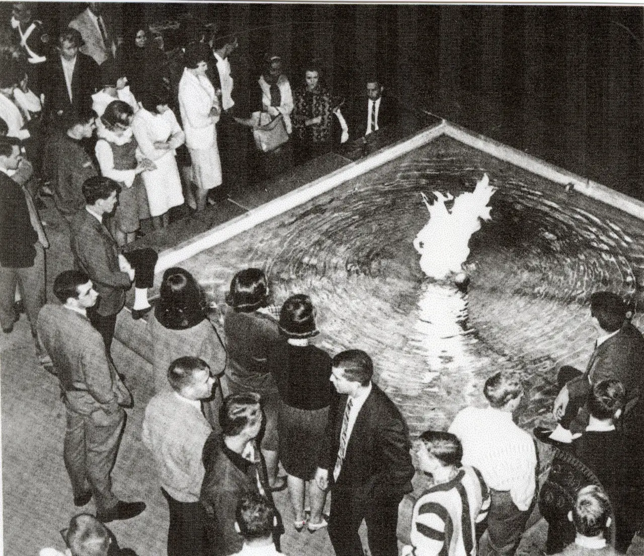 Students gathered around the Victory Flame, burning in a shallow pool