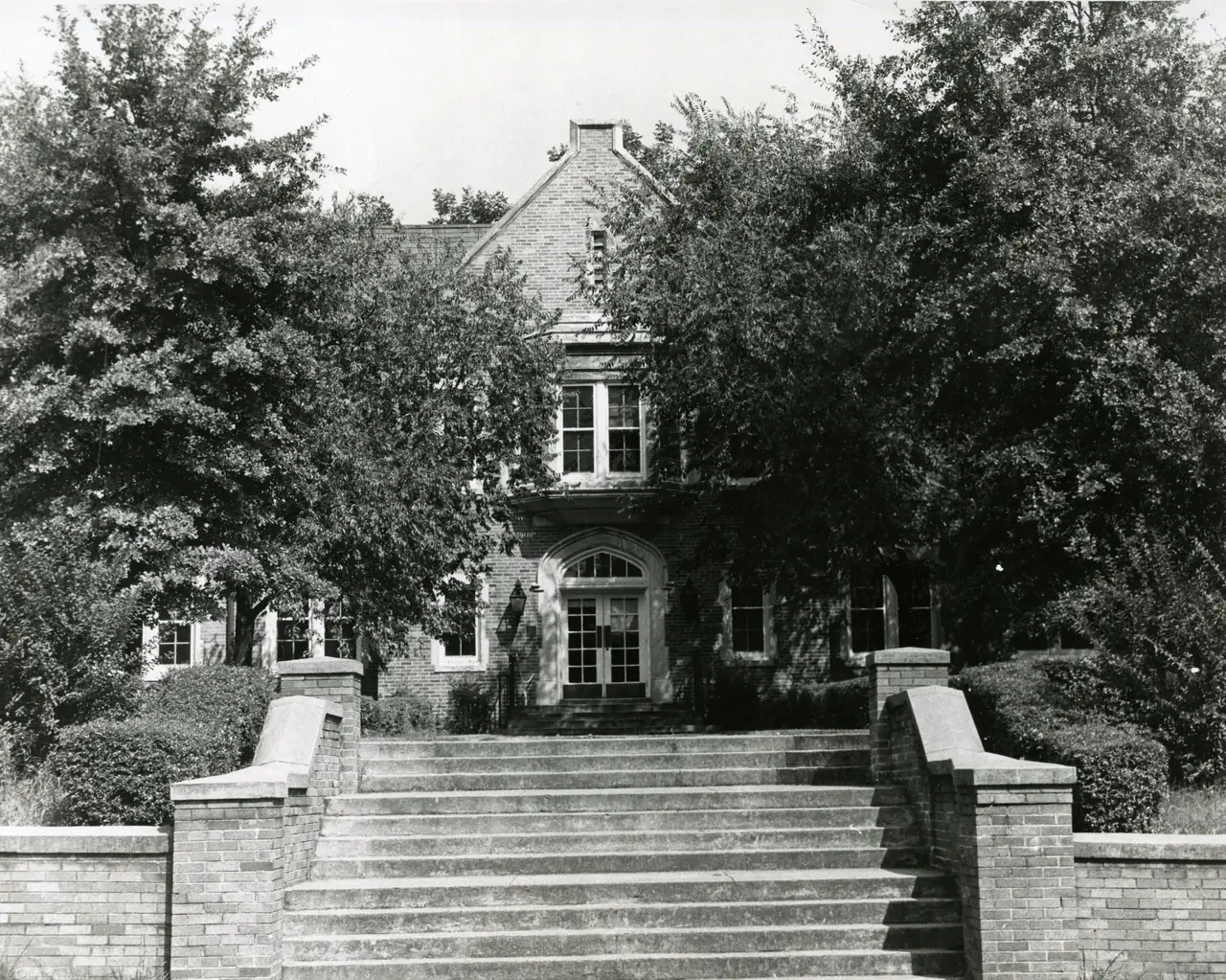 Willingham Hall, a two-story brick building with a broad entrance stair, half hidden by trees