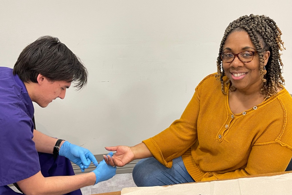 UNA student examining a UNA employee's hand